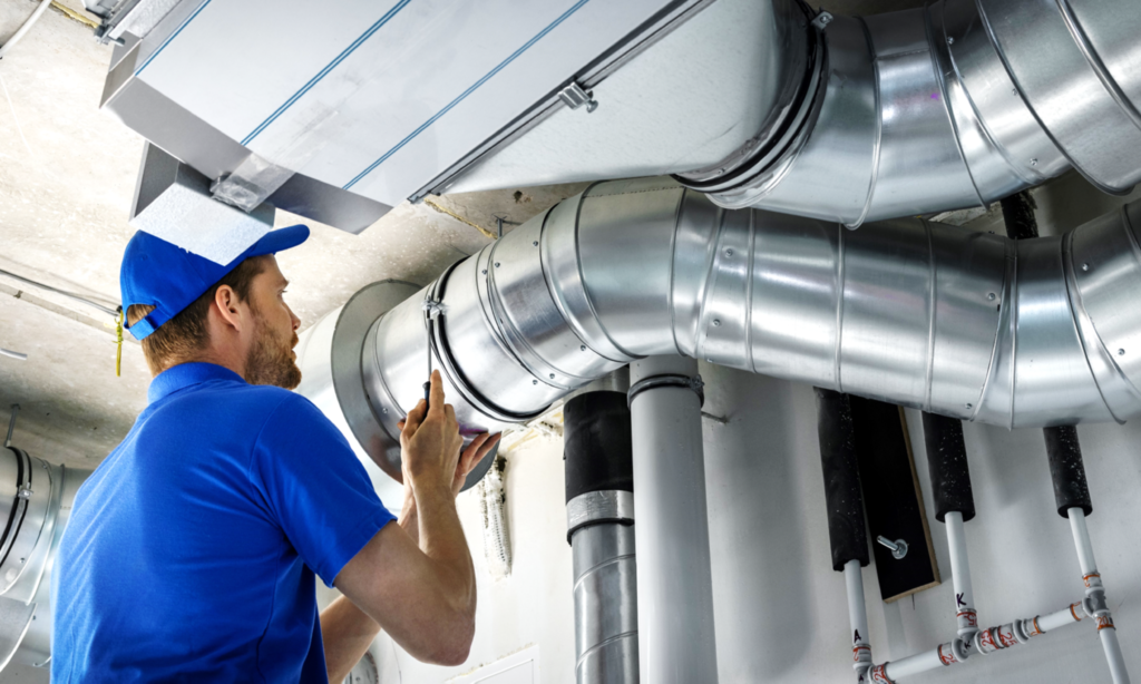 Person Installing HVAC Piping in Building Image